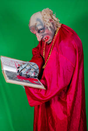 Evil Gnome is reading the book of the dead with spells (1). Idea for covers of books and magazines, for commercial ads and articles.の写真素材