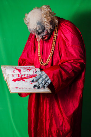 Evil Gnome is reading the book of the dead with spells (4). Idea for covers of books and magazines, for commercial ads and articles.の写真素材
