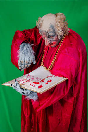 Evil Gnome is reading the book of the dead with spells (2). Idea for covers of books and magazines, for commercial ads and articles.の写真素材