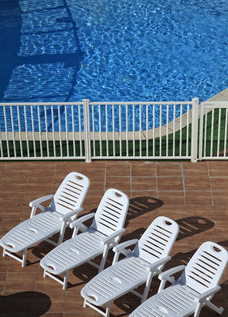four recliners on the bord of the poolの写真素材