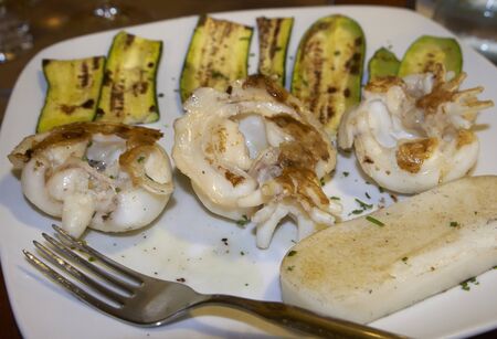 skewers of grilled cuttlefish with zucchini and white polenta, italian foodの写真素材
