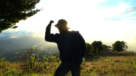 Man very happy, feeling good, showing yes sign. Standing on the top of mountains. Success achievementの写真素材
