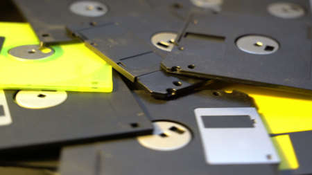 old diskettes data center concept background, female hand take floppy disc from a pileの写真素材