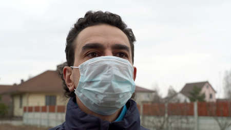 italian man in medical mask outdoors looking scared shocked and frustratedの写真素材