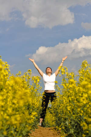 beautiful day for a woman in sports clothing stretching on footpath in the fieldsの写真素材
