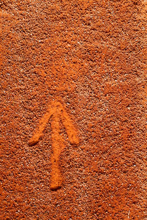 simple arrow drawn fingers in sand, clay marking the direction ofの写真素材
