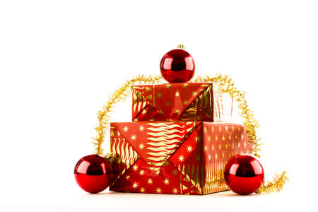Two Christmas presents in red gold wrapping paper with gold ornament and red flasksの写真素材