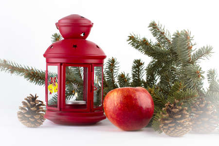 Christmas still life with red apple lamp, evergreens and pineconesの写真素材