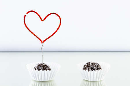Valentine dessert decorated with a heart of red beads strung on wireの写真素材