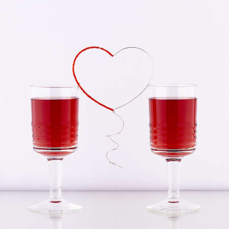 Red heart madeof wire and beads between drinks の写真素材