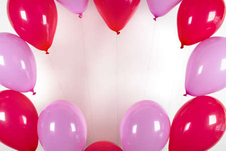frame of pink and red balloons on a white backgroundの写真素材
