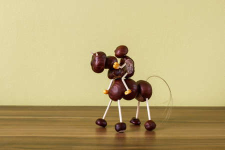 doll horse and horseman made ââof chestnuts on a wooden backgroundの写真素材