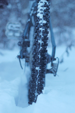 Mountain biking in the winter, Close-up on a background of falling snowの写真素材