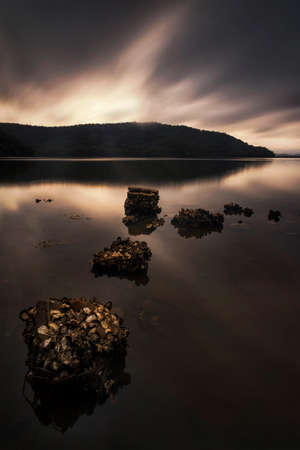 a group of clouds in the sky over a body of waterの写真素材