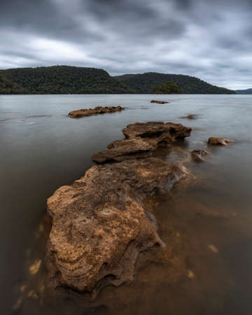 a close up of a rock next to a body of waterの写真素材