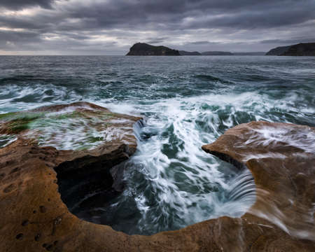 waves hitting the rocks on the oceanの写真素材