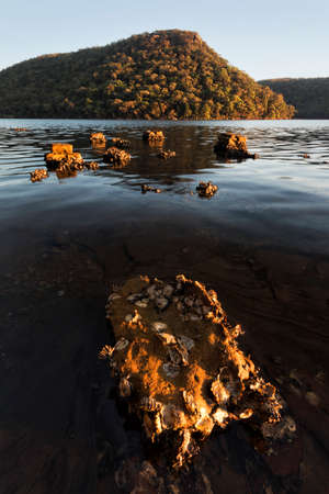 rocks in the lake before a mountainの写真素材