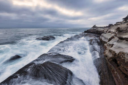 waves over a rock platform in the oceanの写真素材