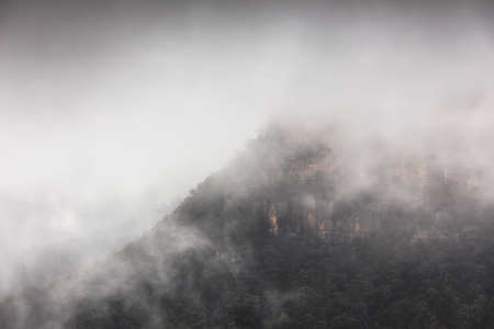 mountain surrounded in mist and fogの写真素材