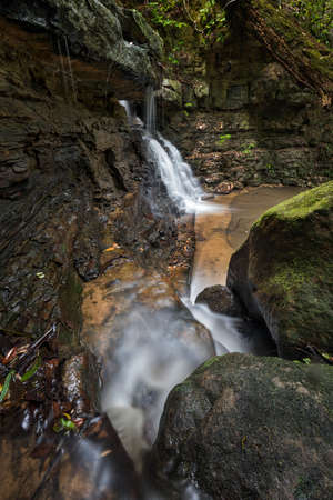 water flowing into a creek with a waterfallの写真素材