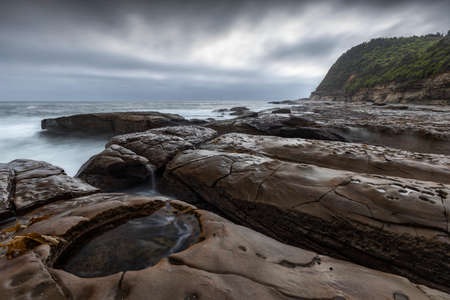 a rocky beach next to the rockpoolの写真素材