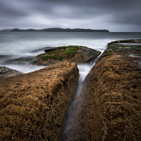 rocks on the coast under overcast skiesの写真素材