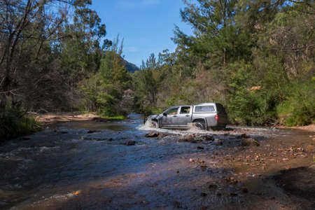 truck 4wd driving through a creek in the bushの写真素材