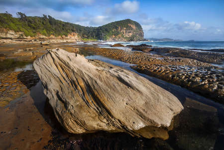 rocks along the shoreline at the beachの写真素材