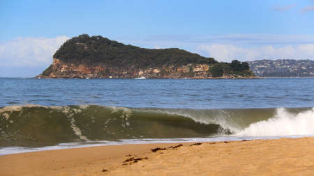 wave breaking on beach near lion islandの写真素材