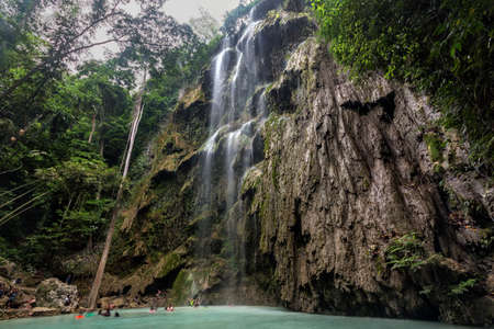 a waterfall with trees on the side of a riverの写真素材