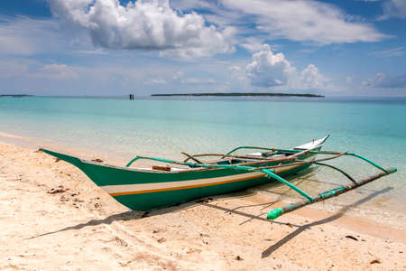 a boat sitting on top of a sandy beachの写真素材