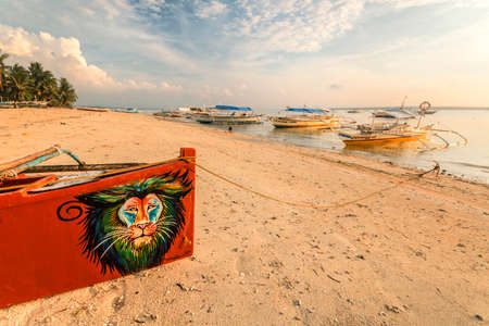 a boat sitting on top of a sandy beachの写真素材