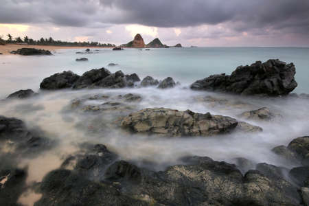 a rocky shore next to a body of waterの写真素材