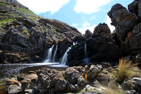 a large waterfall over a rocky cliffの写真素材