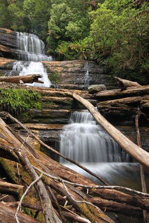 a large waterfall over some water in tasmaniaの写真素材