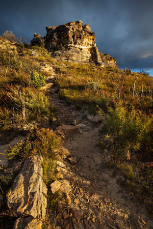 sunlight on the side of a mountain with stormy skyの写真素材