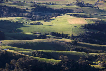 grassy hills and regional land from above with light and shadowsの写真素材