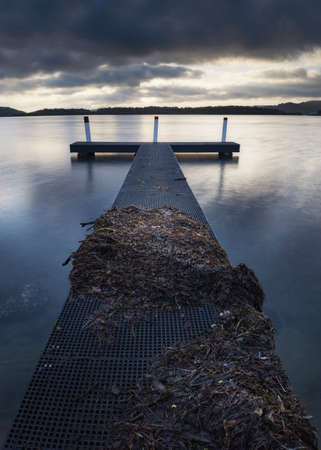 sunrise over calm waters and wharf at woy woy on nsw central coastの写真素材