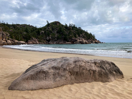 a rock sandy beach next to a body of water at Balding Bay on Magnetic Islandの写真素材