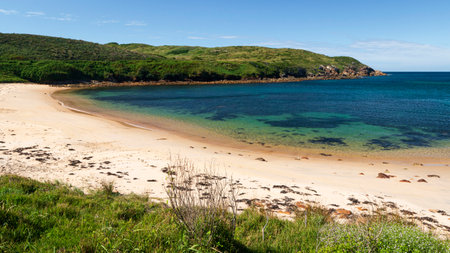 a sandy beach next to a body of water on Broughton Island in Australia