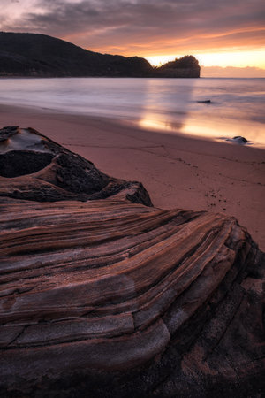 stunning unique rocks at Maitland Bay beach during sunrise on central coast of nsw australiaの写真素材