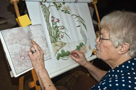 Lady cocertrating on a cross stitch.の写真素材