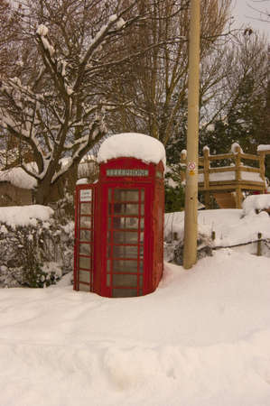 Mantle of snow on red telephone box.の写真素材
