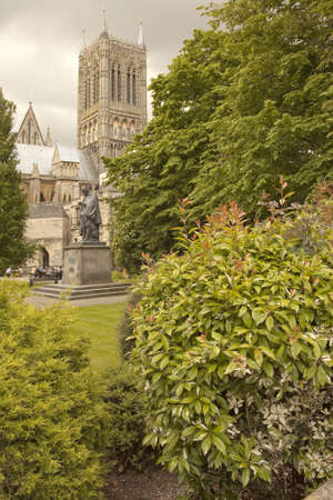 A group of visitors enjoy a lunch time coffee break at the Lincoln Cathedral coffee shop  Lord Alfred Tennison looks though full as his faithfull dog looks on のeditorial素材