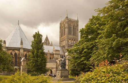 A group of visitors enjoy a lunch time coffee break at the Lincoln Cathedral coffee shop  Lord Alfred Tennison looks though full as his faithfull dog looks on のeditorial素材