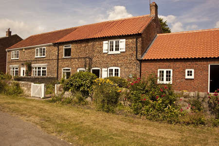 1527  Attractive old cottages on a Yorkshire village green  The cottages have been renovated to a high standard and have retained most of the original features Colourfull flowers make a cheerful display のeditorial素材