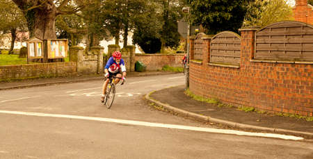 A lone cyclist struggles to catch up with the leaders in this time trial event  staged in Lincolnshire のeditorial素材