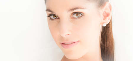 Close up portrait of beautiful bride against white wall