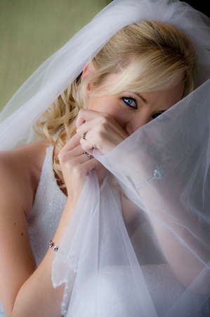 Close up portrait of young beautiful blonde bride with white veilの写真素材
