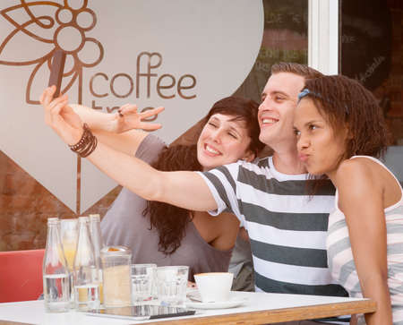 Group of young people taking a selfie together with Smartphoneの写真素材